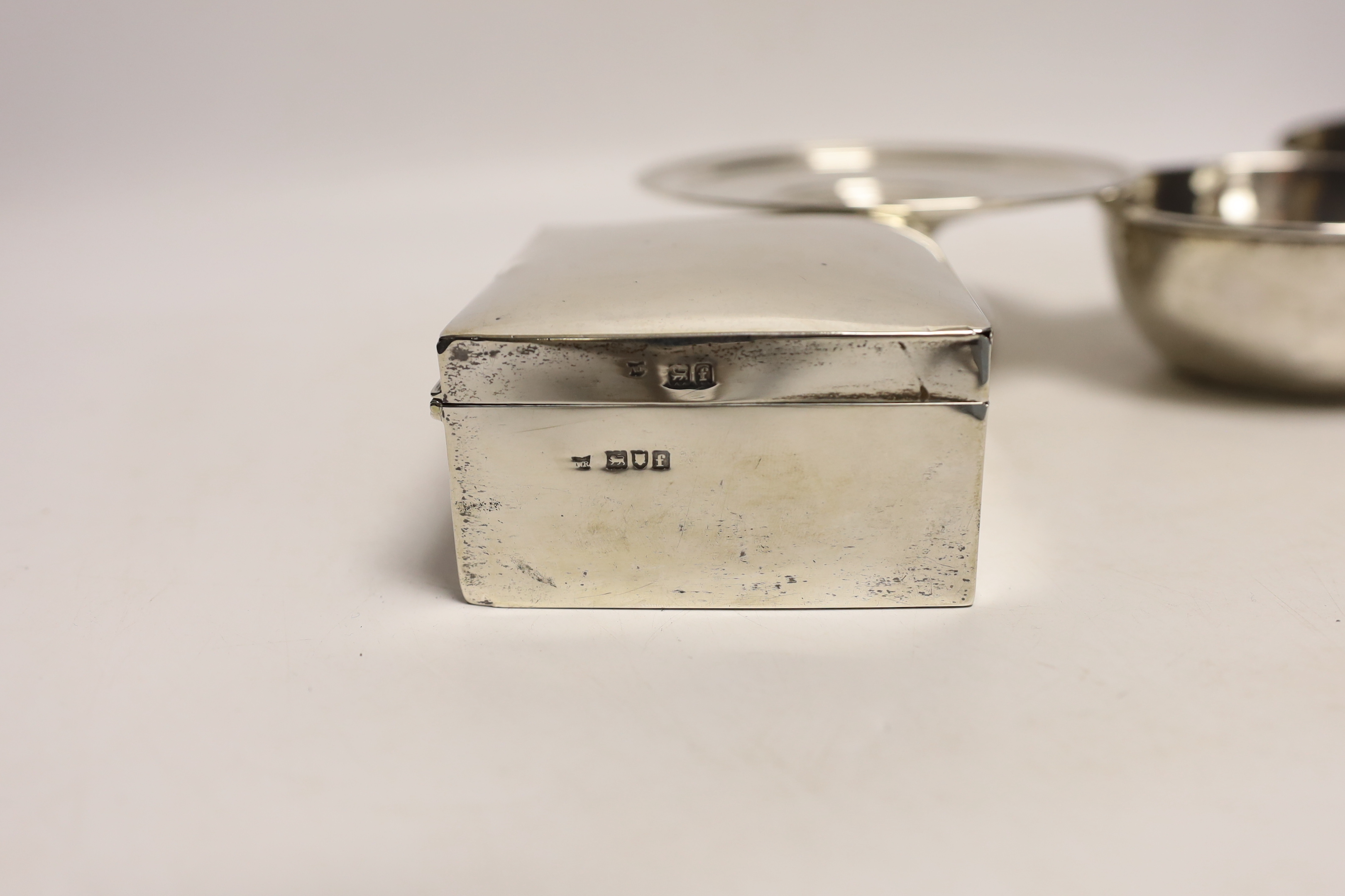 An Edwardian silver mounted cigarette box, London, 1901, 10.8cm, a small silver tazza and two continental white metal bowls, with inset coin bases.
